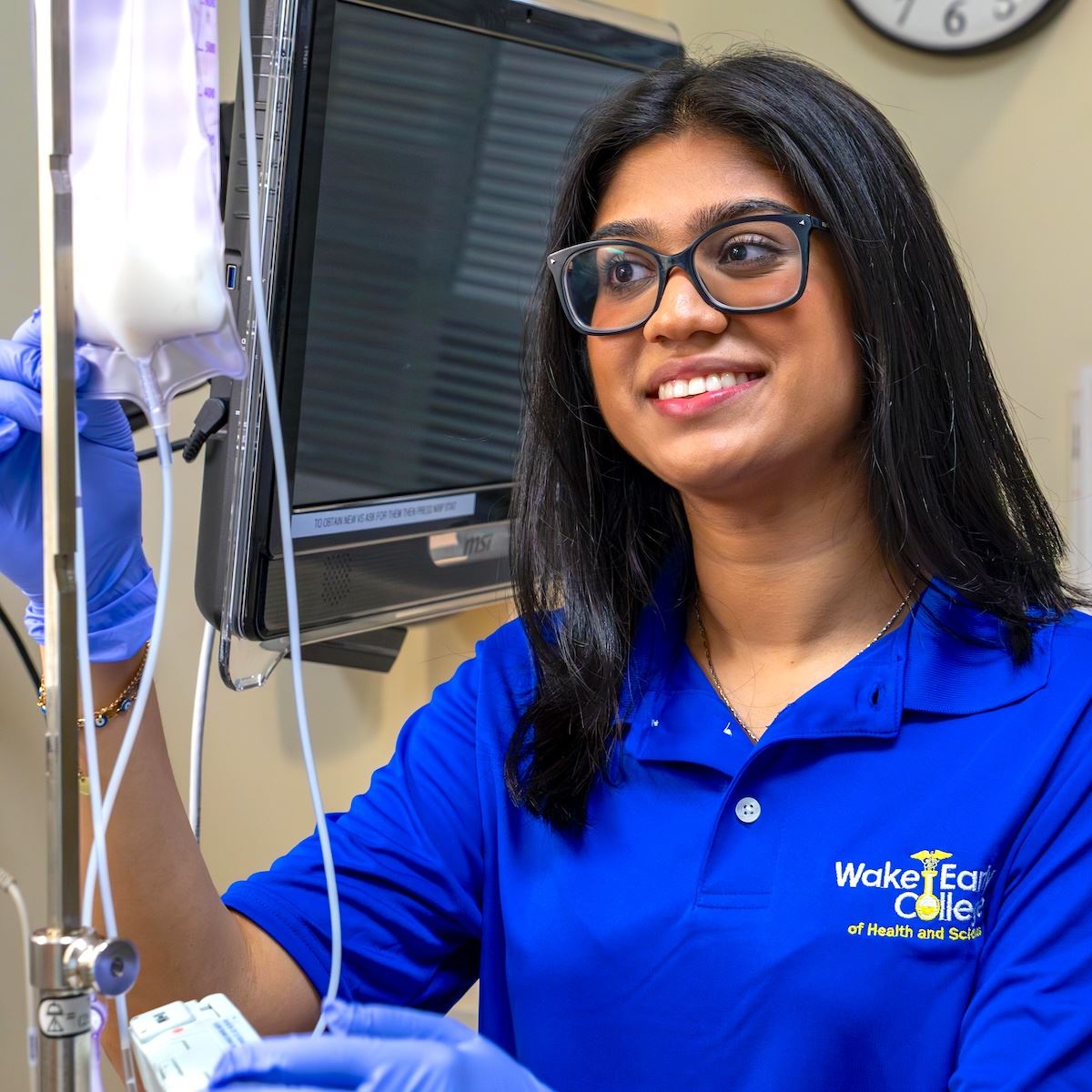  Anya Trivedi smiles while examining an IV bag